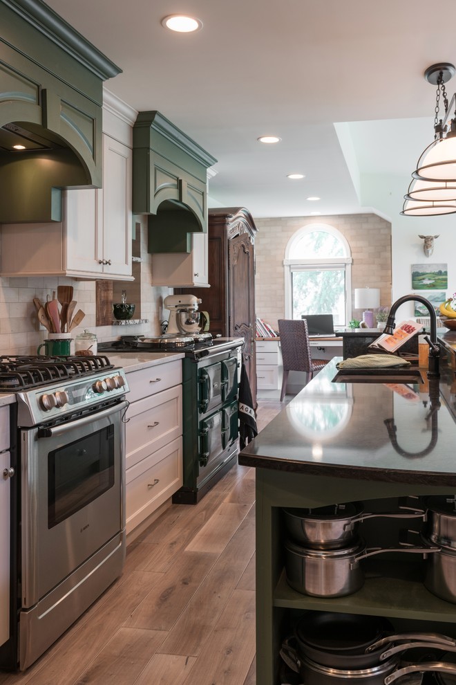Example of a large country galley light wood floor and beige floor eat-in kitchen design in Philadelphia with an undermount sink, flat-panel cabinets, beige cabinets, quartz countertops, beige backsplash, stone tile backsplash, stainless steel appliances and an island