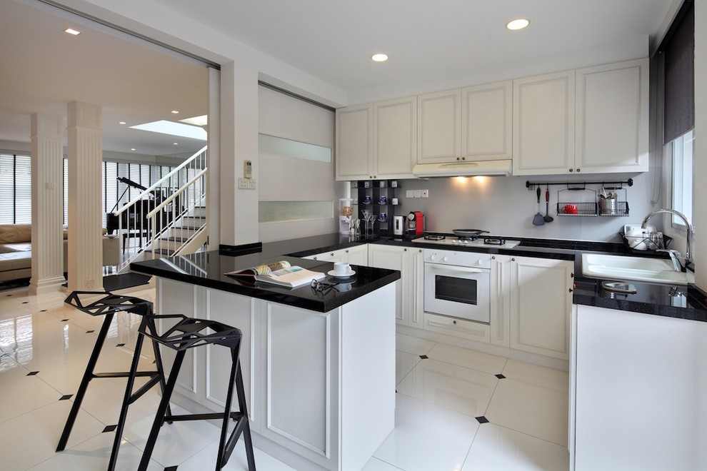 This is an example of a modern kitchen in Singapore with a built-in sink, white appliances, white floors and black worktops.