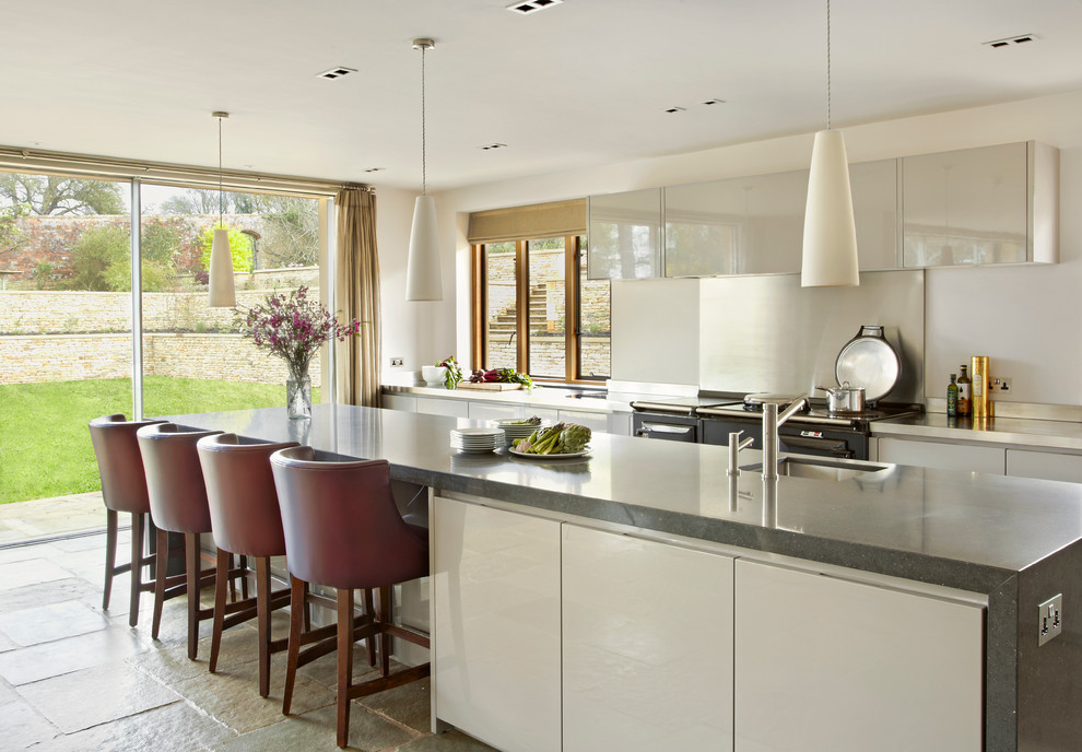 Huge trendy kitchen photo in London with an undermount sink, flat-panel cabinets, gray cabinets and an island