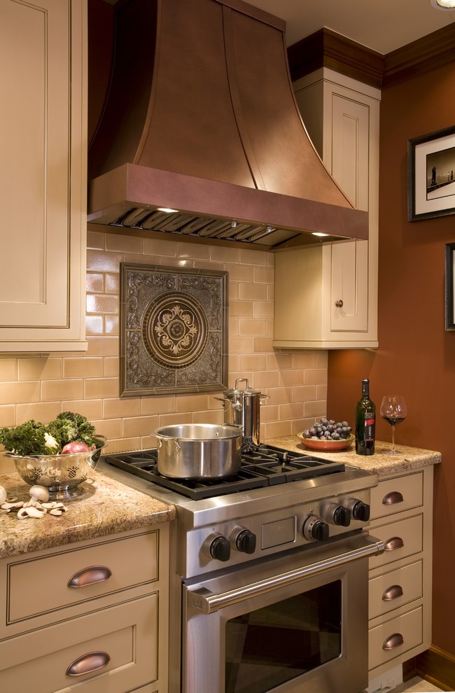 Kitchen - traditional kitchen idea in Portland with stainless steel appliances, granite countertops, beige cabinets, brown backsplash and subway tile backsplash