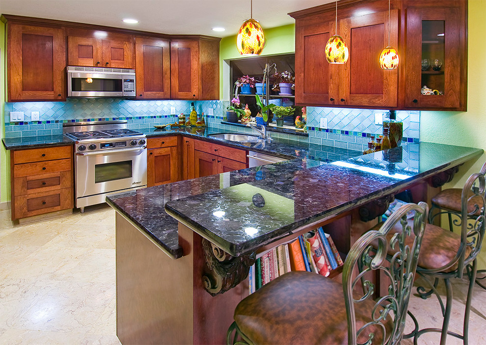 Exempel på ett mellanstort, avskilt eklektiskt u-kök, med skåp i shakerstil, skåp i mellenmörkt trä, granitbänkskiva, en halv köksö, en undermonterad diskho, blått stänkskydd, stänkskydd i keramik, rostfria vitvaror och travertin golv