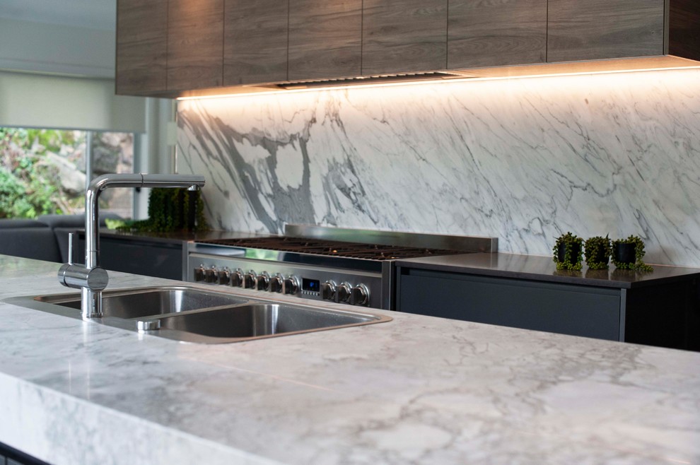 Idee per una grande cucina contemporanea con lavello da incasso, top in marmo, paraspruzzi in lastra di pietra e elettrodomestici neri
