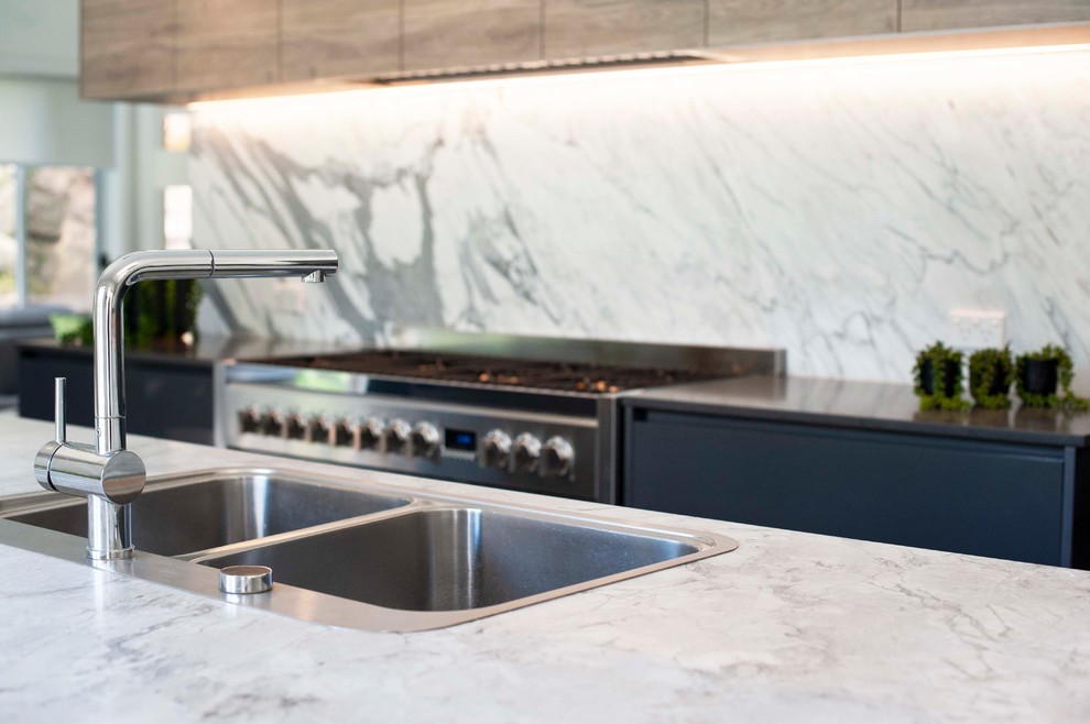 Esempio di una grande cucina minimal con lavello da incasso, top in marmo, paraspruzzi in lastra di pietra e elettrodomestici neri
