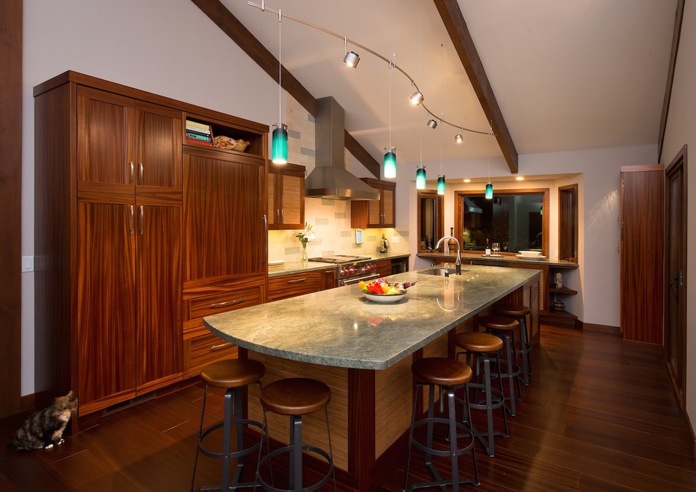 Mid-sized transitional l-shaped dark wood floor and brown floor open concept kitchen photo in Other with an undermount sink, recessed-panel cabinets, medium tone wood cabinets, granite countertops, beige backsplash, stone tile backsplash, stainless steel appliances and an island