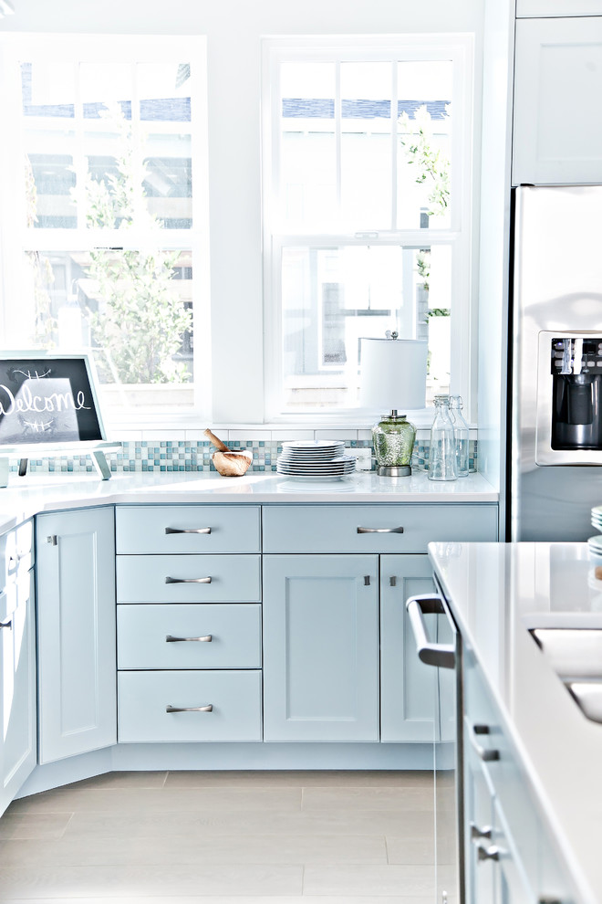 Esempio di una cucina costiera di medie dimensioni con lavello a doppia vasca, ante in stile shaker, ante blu, top in quarzite, paraspruzzi bianco, paraspruzzi con piastrelle diamantate, elettrodomestici in acciaio inossidabile, parquet chiaro e pavimento beige