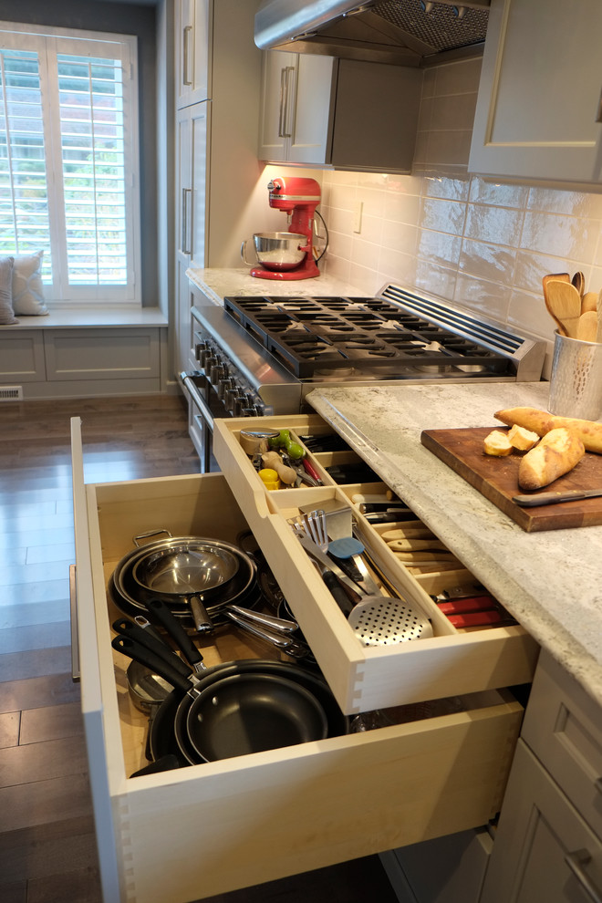 Inspiration for a large traditional kitchen/diner in Seattle with a submerged sink, shaker cabinets, grey cabinets, engineered stone countertops, white splashback, porcelain splashback, stainless steel appliances, medium hardwood flooring and an island.