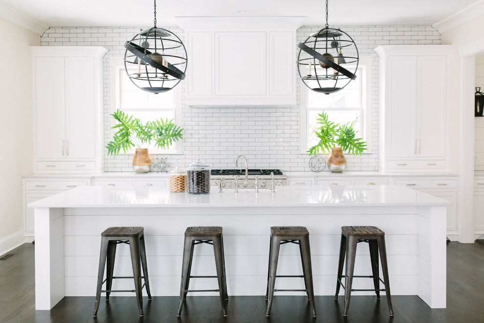 Transitional l-shaped dark wood floor eat-in kitchen photo in Chicago with shaker cabinets, white cabinets, quartz countertops, white backsplash, subway tile backsplash, stainless steel appliances and an island