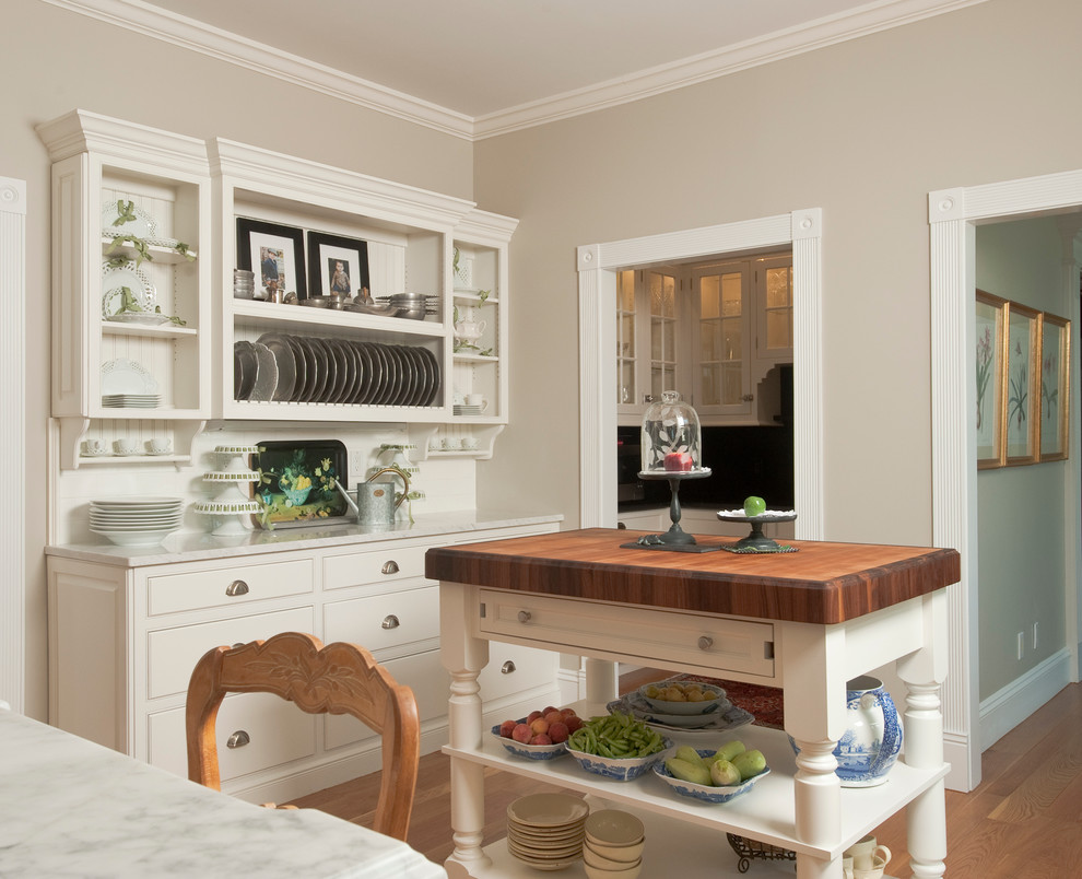 Ejemplo de cocina clásica con armarios con rebordes decorativos, puertas de armario blancas, encimera de mármol y salpicadero blanco