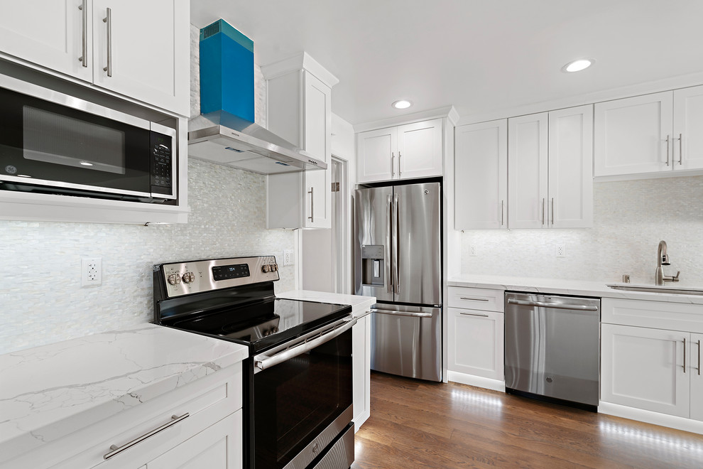 Photo of a medium sized modern u-shaped enclosed kitchen in San Francisco with a submerged sink, shaker cabinets, white cabinets, quartz worktops, white splashback, stainless steel appliances, medium hardwood flooring, no island, brown floors and white worktops.