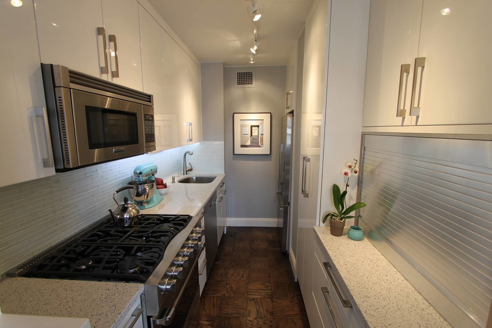 Small trendy galley dark wood floor eat-in kitchen photo in New York with a single-bowl sink, flat-panel cabinets, white cabinets, quartz countertops, blue backsplash, glass tile backsplash, stainless steel appliances and no island