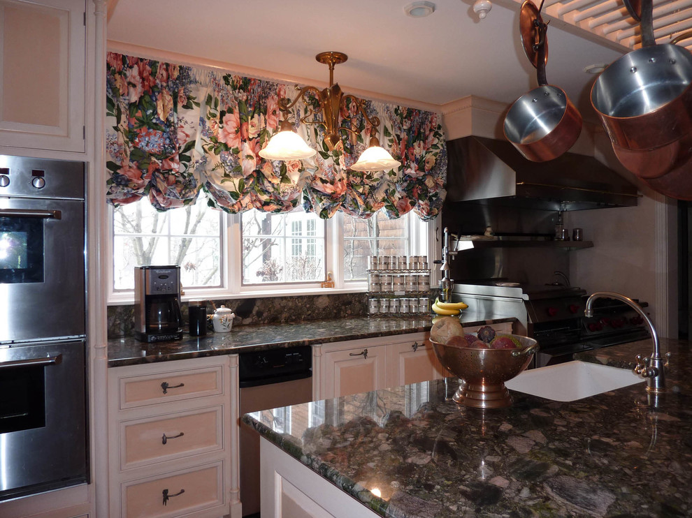Klassisk inredning av ett avskilt, stort u-kök, med en rustik diskho, luckor med infälld panel, beige skåp, bänkskiva i kvartsit, stänkskydd med metallisk yta, stänkskydd i metallkakel, rostfria vitvaror och en köksö