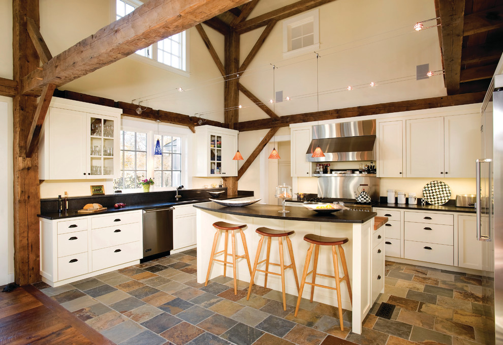 Foto de cocina campestre con armarios tipo vitrina, electrodomésticos de acero inoxidable y suelo multicolor