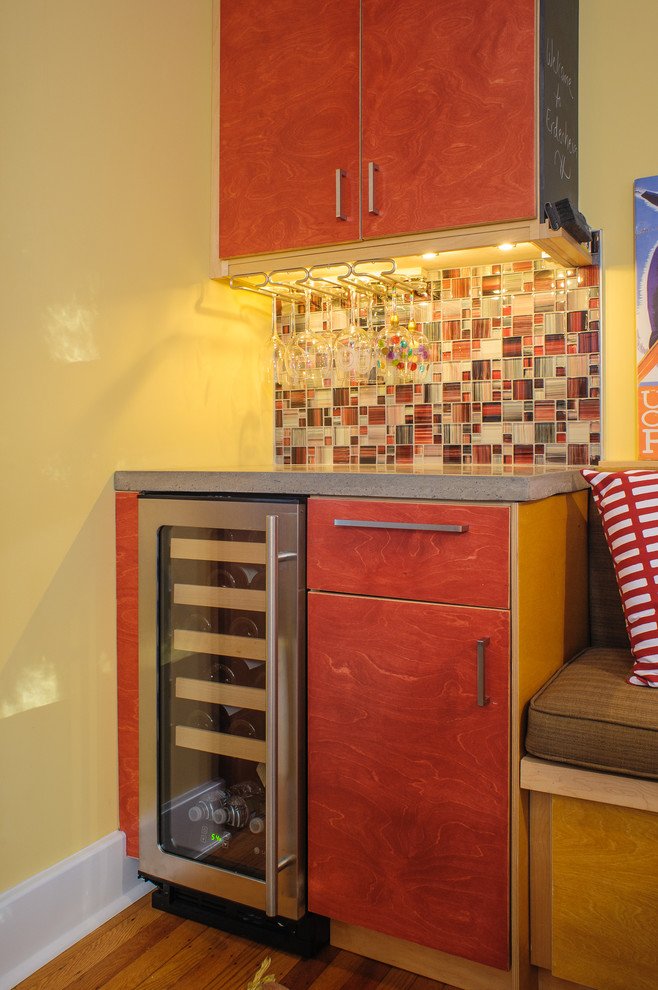 Foto di un cucina con isola centrale moderno con lavello stile country, ante lisce, ante rosse, top in cemento, paraspruzzi con piastrelle di vetro e elettrodomestici in acciaio inossidabile