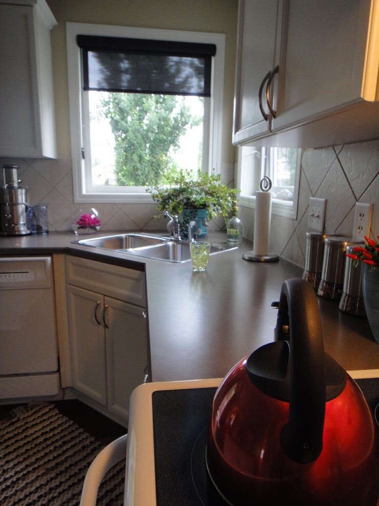 Example of a mid-sized classic u-shaped dark wood floor eat-in kitchen design in Edmonton with a double-bowl sink, recessed-panel cabinets, white cabinets, laminate countertops, beige backsplash, ceramic backsplash, white appliances and an island