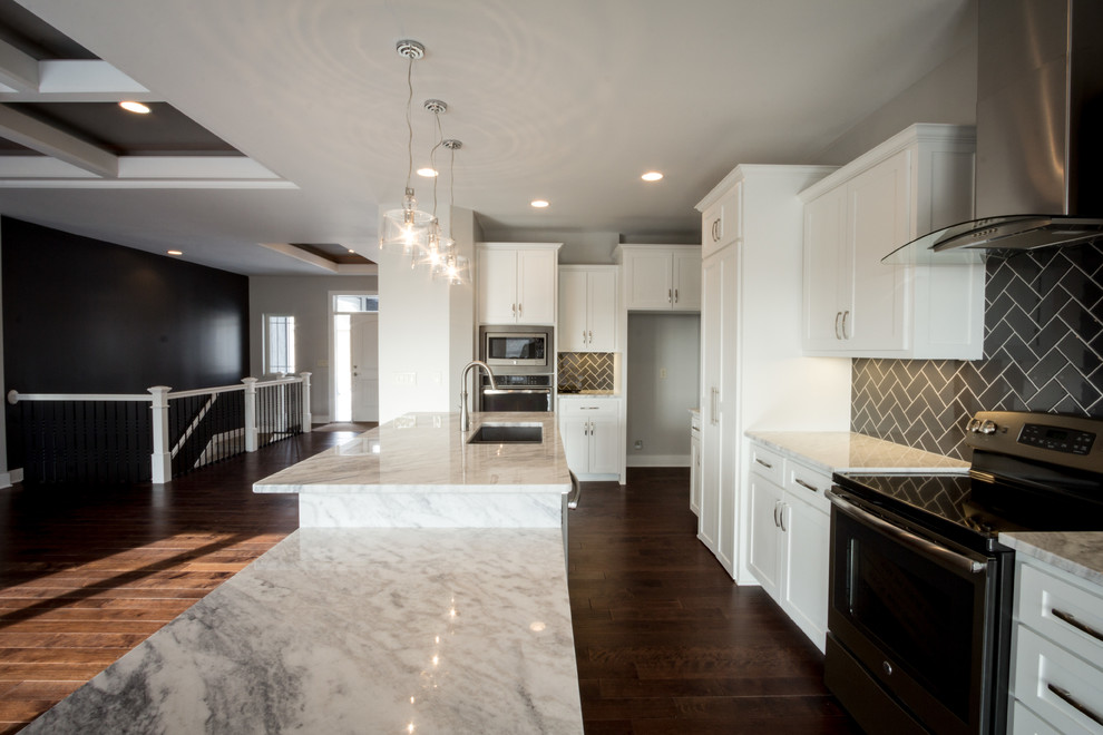 Mid-sized minimalist l-shaped dark wood floor eat-in kitchen photo in Omaha with an undermount sink, shaker cabinets, white cabinets, granite countertops, gray backsplash, subway tile backsplash, stainless steel appliances and an island