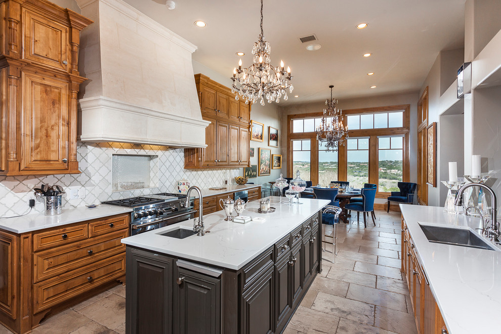Example of an ornate galley kitchen design in Austin with an undermount sink, raised-panel cabinets, medium tone wood cabinets, white backsplash, stainless steel appliances and an island