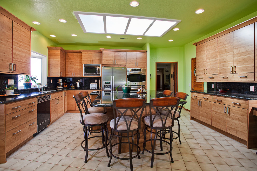 Example of a minimalist u-shaped eat-in kitchen design in San Diego with a drop-in sink, flat-panel cabinets, light wood cabinets, granite countertops, multicolored backsplash, stone slab backsplash and stainless steel appliances