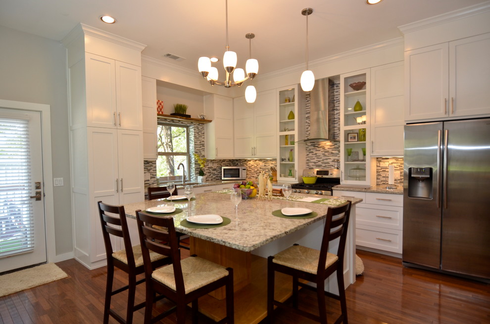 Foto de cocina clásica renovada con salpicadero de azulejos en listel y electrodomésticos de acero inoxidable