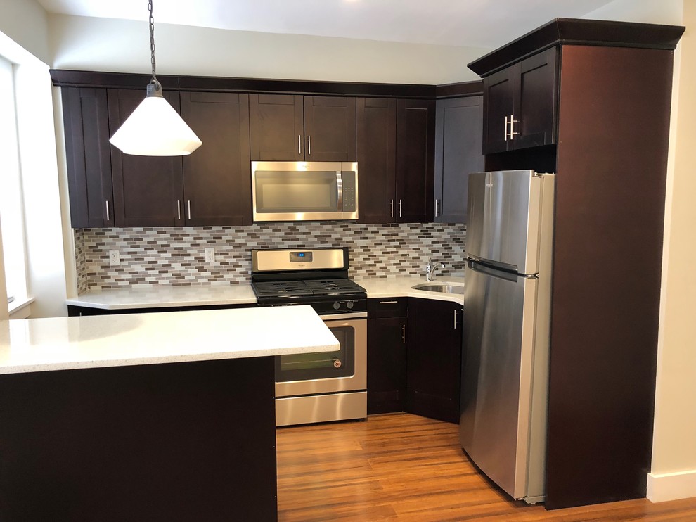 Small trendy l-shaped light wood floor and brown floor open concept kitchen photo in New York with a single-bowl sink, shaker cabinets, dark wood cabinets, quartz countertops, multicolored backsplash, mosaic tile backsplash, stainless steel appliances, a peninsula and white countertops