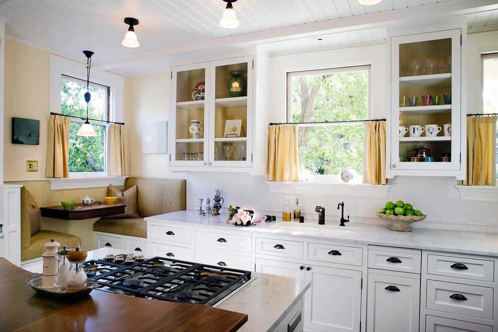 Стильный дизайн: кухня в классическом стиле с фартуком из удлиненной плитки и шторами на окнах - последний тренд