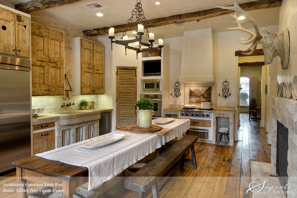 Landhausstil Küche mit Landhausspüle, Kalkstein-Arbeitsplatte, Rückwand aus Steinfliesen, Küchengeräten aus Edelstahl und braunem Holzboden in Houston