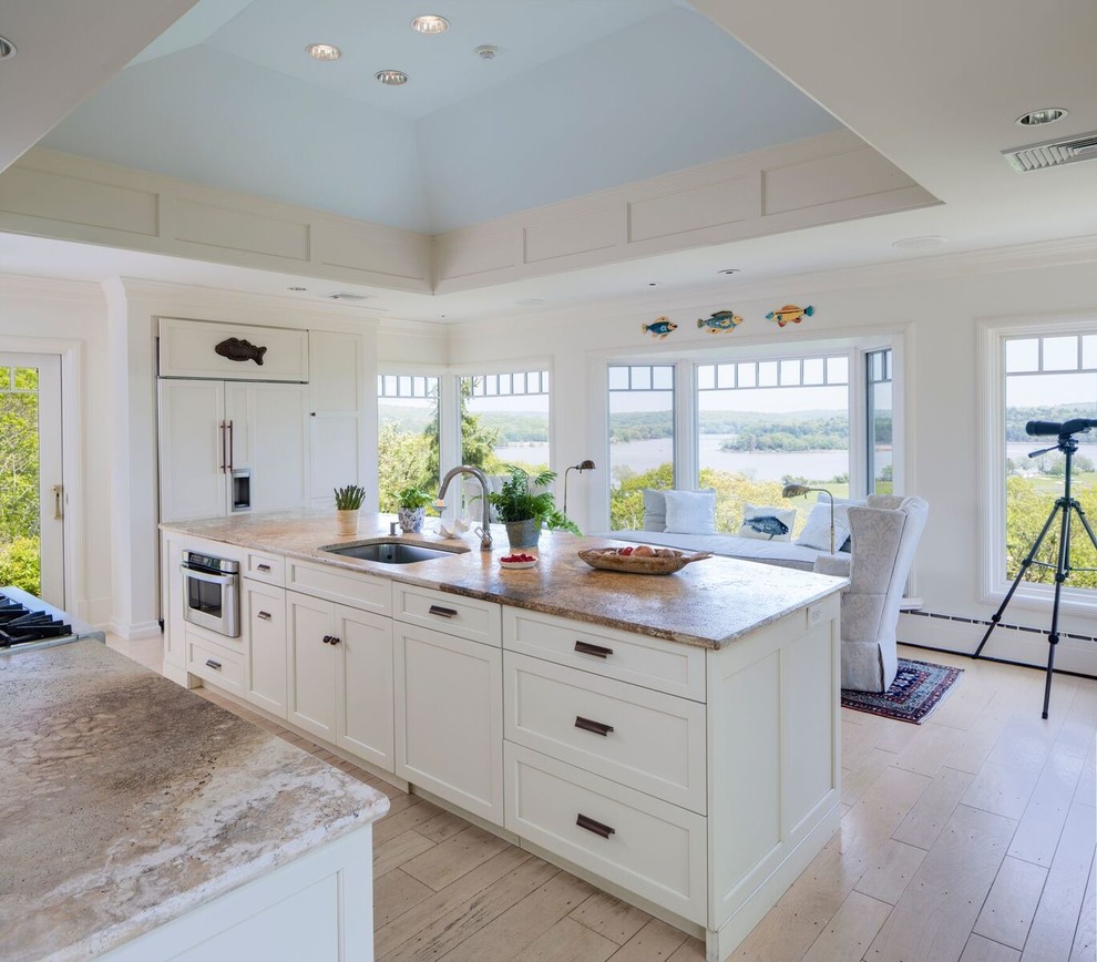 Mid-sized trendy single-wall painted wood floor and beige floor enclosed kitchen photo in Other with an undermount sink, flat-panel cabinets, beige cabinets, limestone countertops, stone slab backsplash, colored appliances and an island