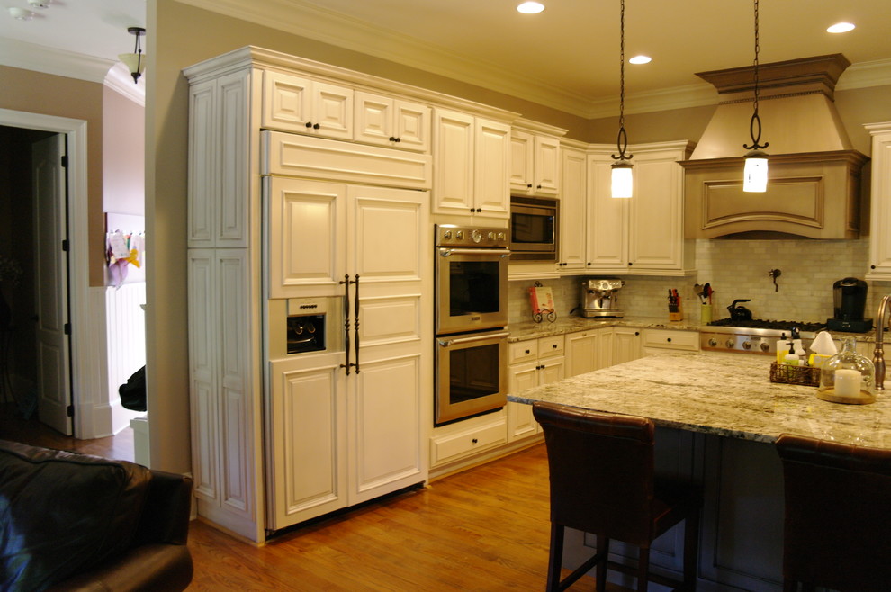 Exempel på ett lantligt kök, med luckor med upphöjd panel och en köksö