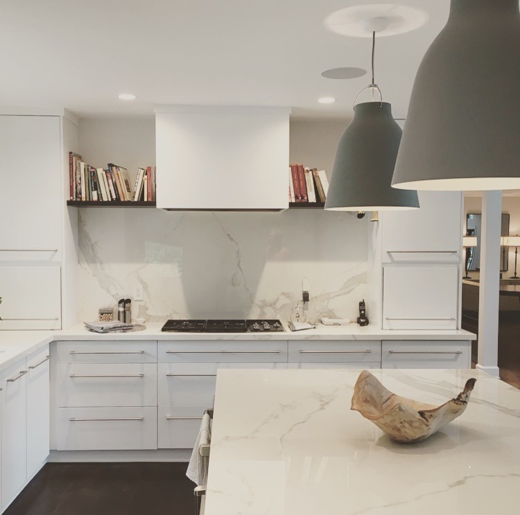 Kitchen - mid-sized contemporary kitchen idea in Atlanta with flat-panel cabinets, white cabinets, solid surface countertops, white backsplash, stone slab backsplash, an island and white countertops