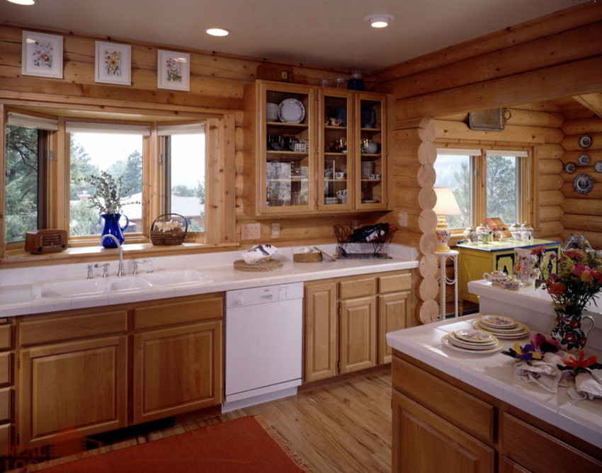 Wohnküche in U-Form mit Triple-Waschtisch, profilierten Schrankfronten, hellbraunen Holzschränken, weißen Elektrogeräten und braunem Holzboden in Burlington