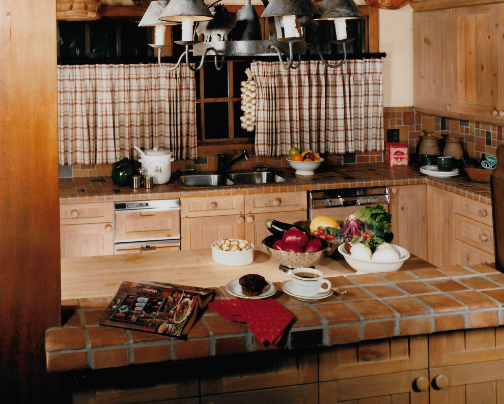 Geschlossene, Mittelgroße Rustikale Küche in U-Form mit Einbauwaschbecken, Kassettenfronten, hellen Holzschränken, Arbeitsplatte aus Fliesen, bunter Rückwand, Rückwand aus Mosaikfliesen, bunten Elektrogeräten, braunem Holzboden und Kücheninsel in Denver