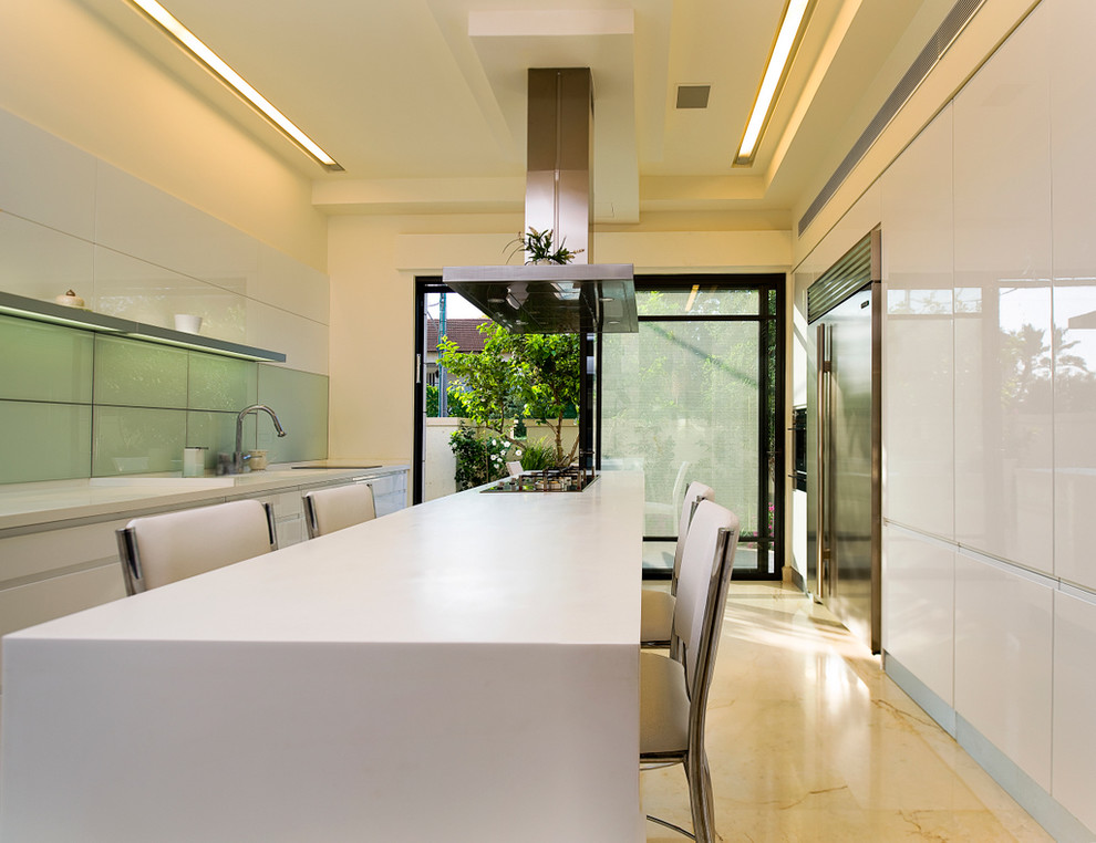 Modern enclosed kitchen in Other with stainless steel appliances, flat-panel cabinets, white cabinets and glass sheet splashback.