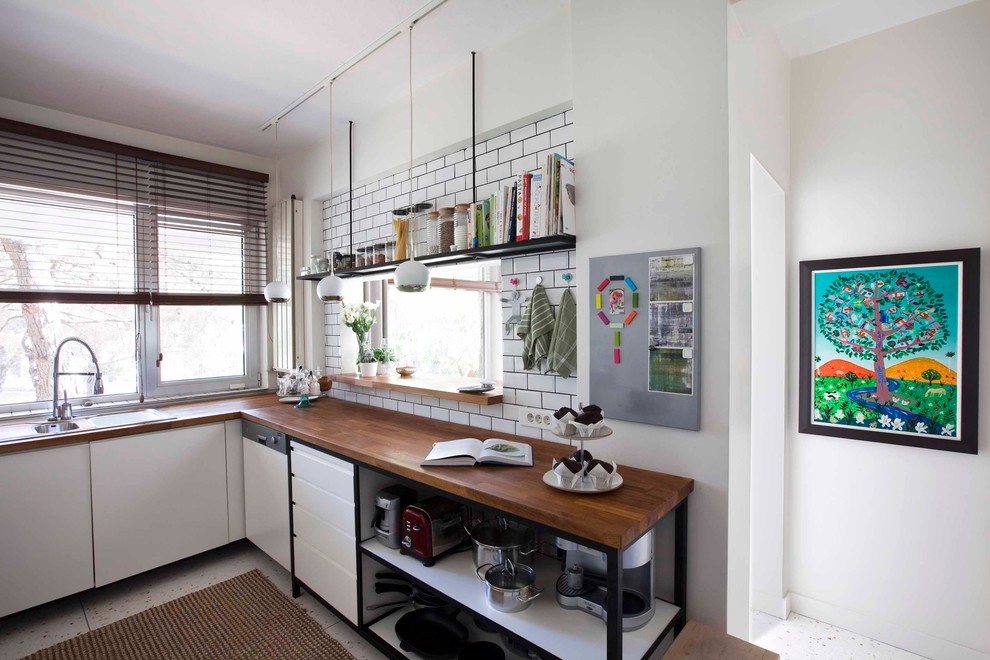 Imagen de cocina industrial con encimera de madera, salpicadero blanco y salpicadero de azulejos tipo metro