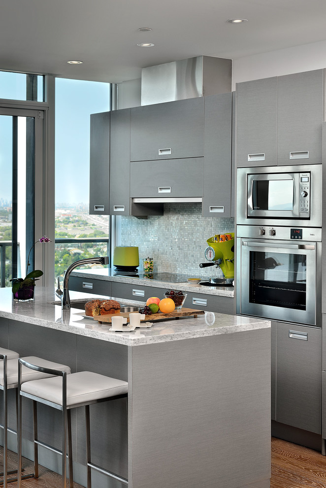 Example of a trendy galley kitchen design in Toronto with marble countertops, stainless steel appliances, flat-panel cabinets and gray cabinets