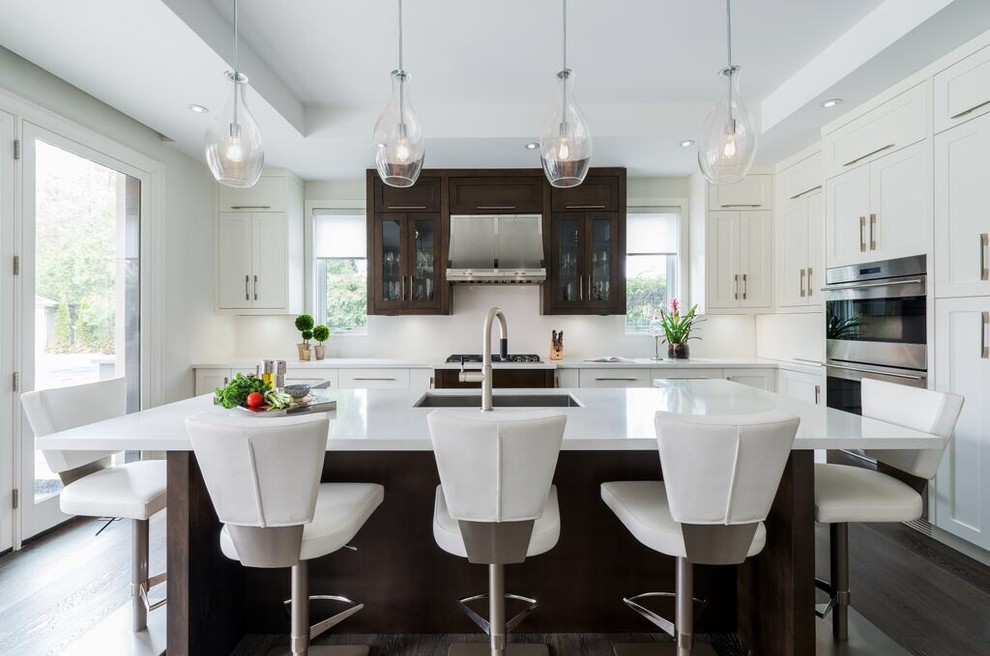 Design ideas for a classic kitchen in Toronto with a submerged sink, shaker cabinets, white cabinets, stainless steel appliances, dark hardwood flooring and an island.