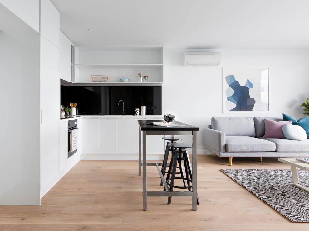 Offene Moderne Küche in L-Form mit offenen Schränken, Küchenrückwand in Schwarz, hellem Holzboden und Kücheninsel in Melbourne