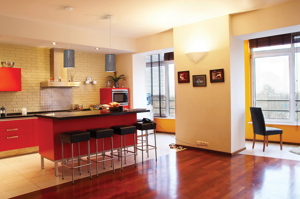 Пример оригинального дизайна: прямая кухня среднего размера в современном стиле с обеденным столом, плоскими фасадами, красными фасадами, столешницей из оникса, бежевым фартуком, техникой из нержавеющей стали, полом из керамогранита и островом