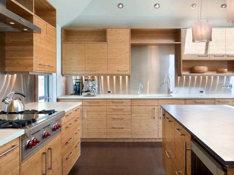Inspiration for a large modern l-shaped open plan kitchen in Orange County with a single-bowl sink, flat-panel cabinets, light wood cabinets, engineered stone countertops, metal splashback, stainless steel appliances, medium hardwood flooring, an island and brown floors.