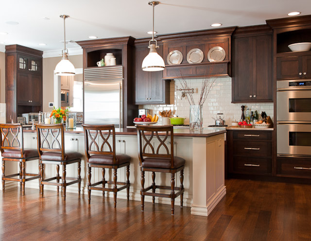 Mid-sized elegant single-wall medium tone wood floor eat-in kitchen photo in New York with shaker cabinets, dark wood cabinets, marble countertops, white backsplash, subway tile backsplash, stainless steel appliances and an island