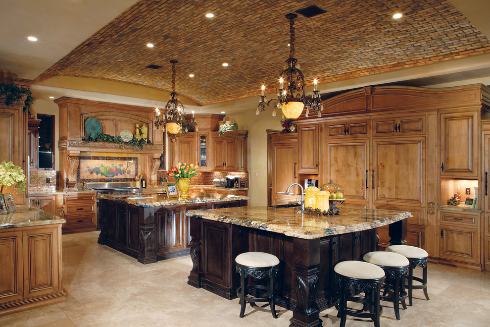 Example of a huge tuscan u-shaped travertine floor eat-in kitchen design in Phoenix with a farmhouse sink, beaded inset cabinets, medium tone wood cabinets, granite countertops, multicolored backsplash, paneled appliances, two islands and stone tile backsplash