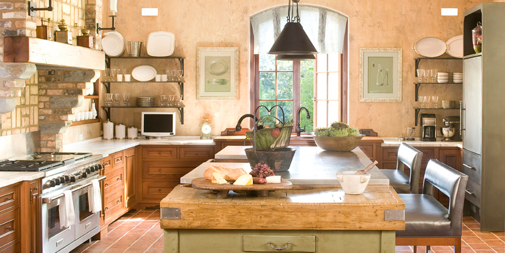 Inredning av ett klassiskt avskilt kök, med luckor med infälld panel, skåp i mellenmörkt trä, träbänkskiva och rostfria vitvaror