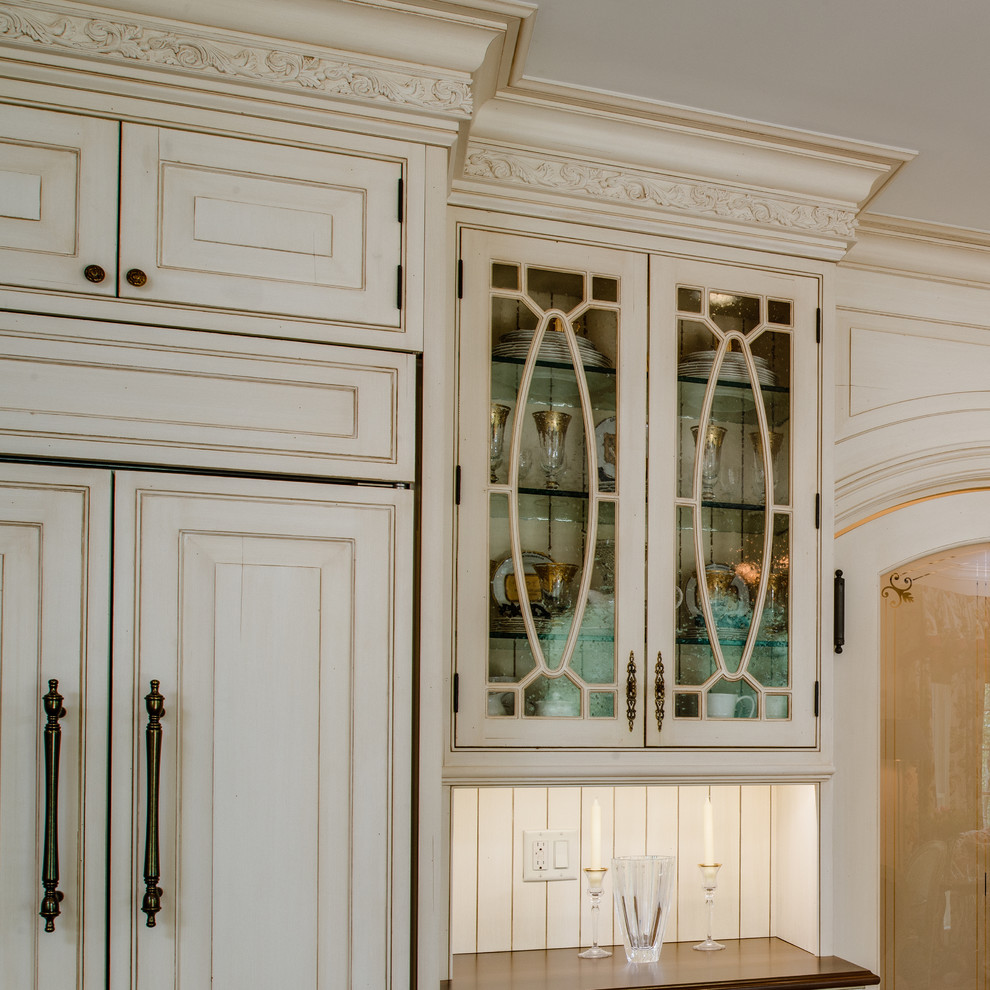 Bild på ett mellanstort vintage u-kök, med en undermonterad diskho, luckor med profilerade fronter, vita skåp, granitbänkskiva, beige stänkskydd, stänkskydd i keramik, integrerade vitvaror, mellanmörkt trägolv och en köksö