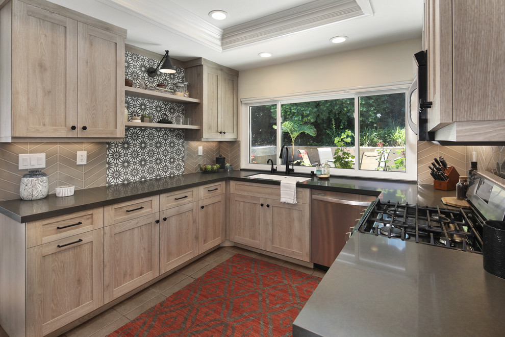 Example of a mid-sized transitional u-shaped kitchen design in Orange County with an undermount sink, shaker cabinets, distressed cabinets, quartz countertops, stainless steel appliances, an island and gray countertops