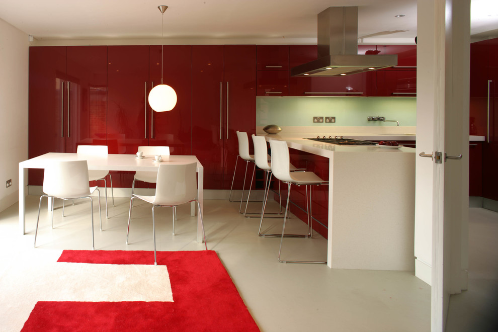 Exempel på ett litet modernt kök, med en integrerad diskho, släta luckor, röda skåp, blått stänkskydd, glaspanel som stänkskydd, rostfria vitvaror, klinkergolv i keramik och en köksö