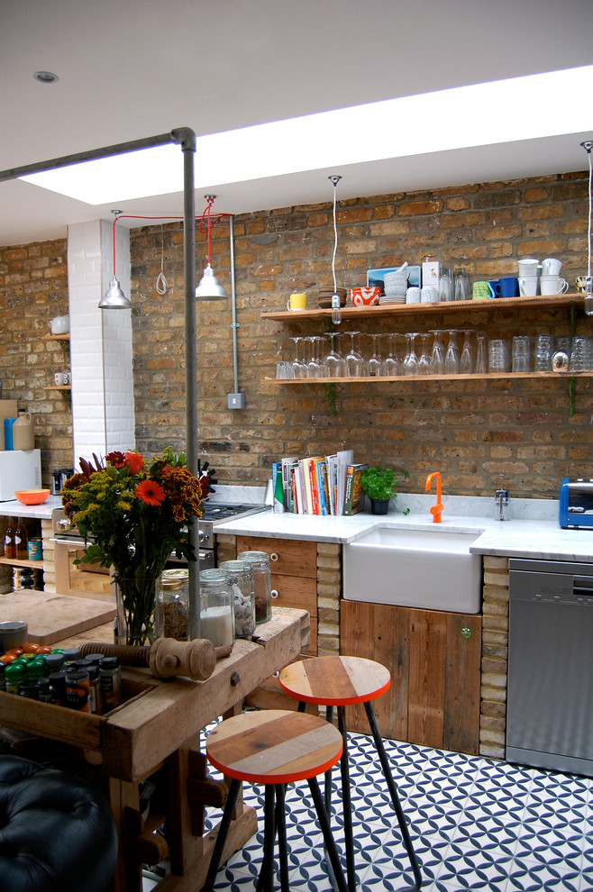 ロンドンにあるエクレクティックスタイルのおしゃれなアイランドキッチン (エプロンフロントシンク、ヴィンテージ仕上げキャビネット、サブウェイタイルのキッチンパネル、シルバーの調理設備) の写真