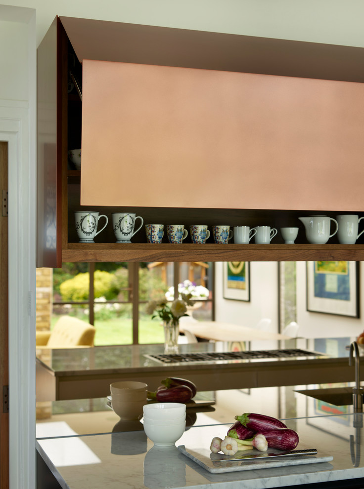 Bild på ett stort funkis vit vitt kök, med en integrerad diskho, blå skåp, marmorbänkskiva, stänkskydd med metallisk yta, spegel som stänkskydd, ljust trägolv, en köksö och brunt golv