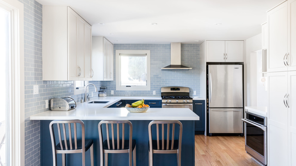 Klassische Küche in U-Form mit Unterbauwaschbecken, Schrankfronten im Shaker-Stil, weißen Schränken, Küchenrückwand in Blau, Küchengeräten aus Edelstahl, braunem Holzboden, braunem Boden und weißer Arbeitsplatte in San Francisco