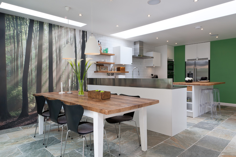 Mid-sized trendy eat-in kitchen photo in Surrey with an integrated sink, flat-panel cabinets, white cabinets, wood countertops, white backsplash, stainless steel appliances, an island and subway tile backsplash