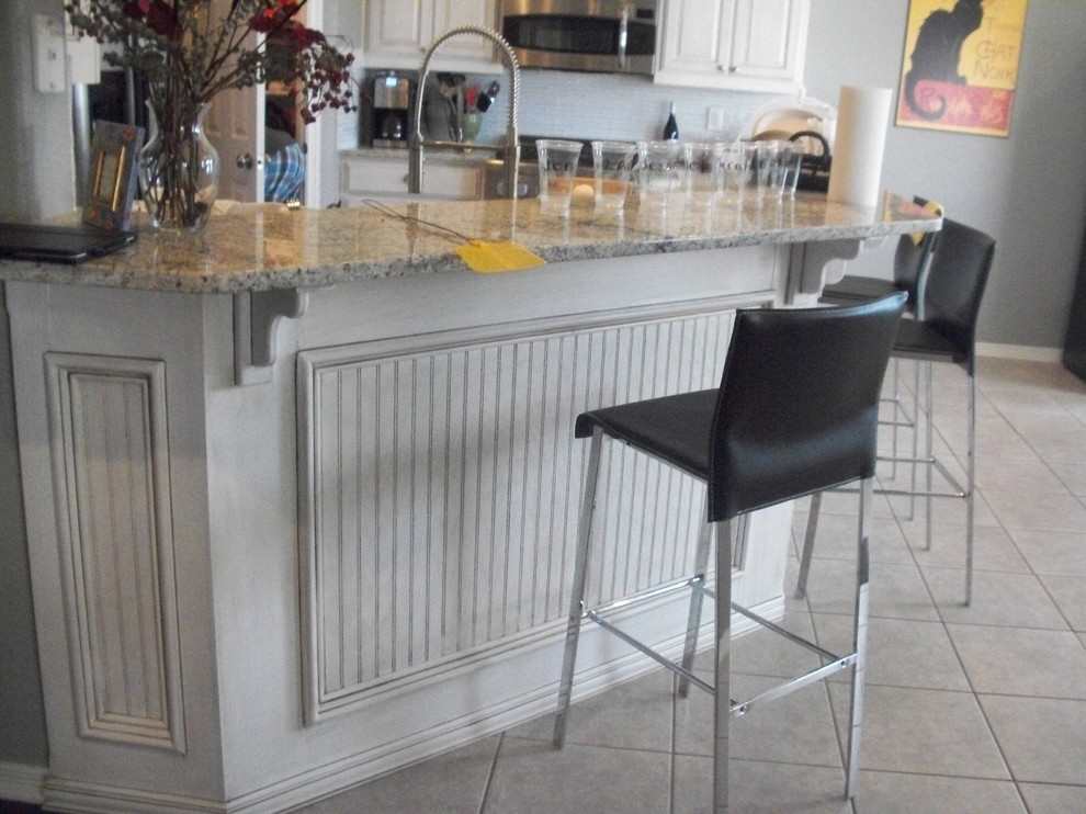 Modern inredning av ett mellanstort kök, med en dubbel diskho, luckor med upphöjd panel, vita skåp, träbänkskiva, vitt stänkskydd, stänkskydd i glaskakel, rostfria vitvaror och klinkergolv i keramik