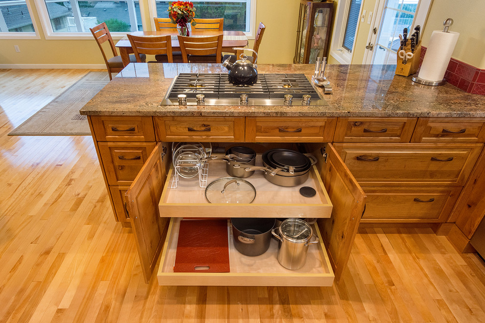 Exempel på ett stort rustikt kök, med en rustik diskho, luckor med upphöjd panel, granitbänkskiva, rött stänkskydd, stänkskydd i keramik, rostfria vitvaror, mellanmörkt trägolv och en köksö