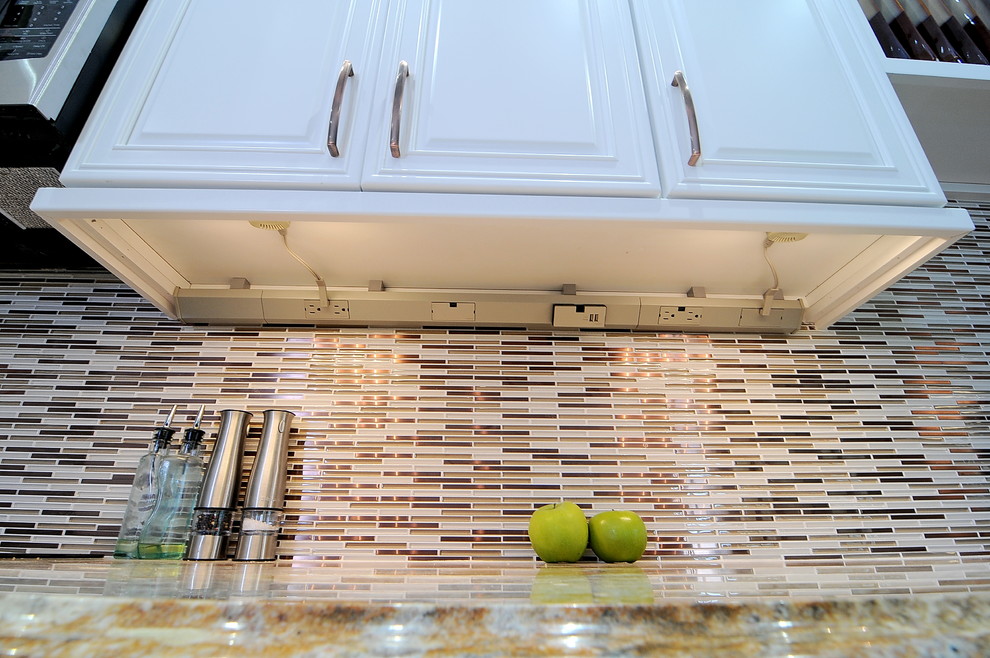 Transitional kitchen photo in Miami with a farmhouse sink, raised-panel cabinets, white cabinets, granite countertops, multicolored backsplash, ceramic backsplash and stainless steel appliances